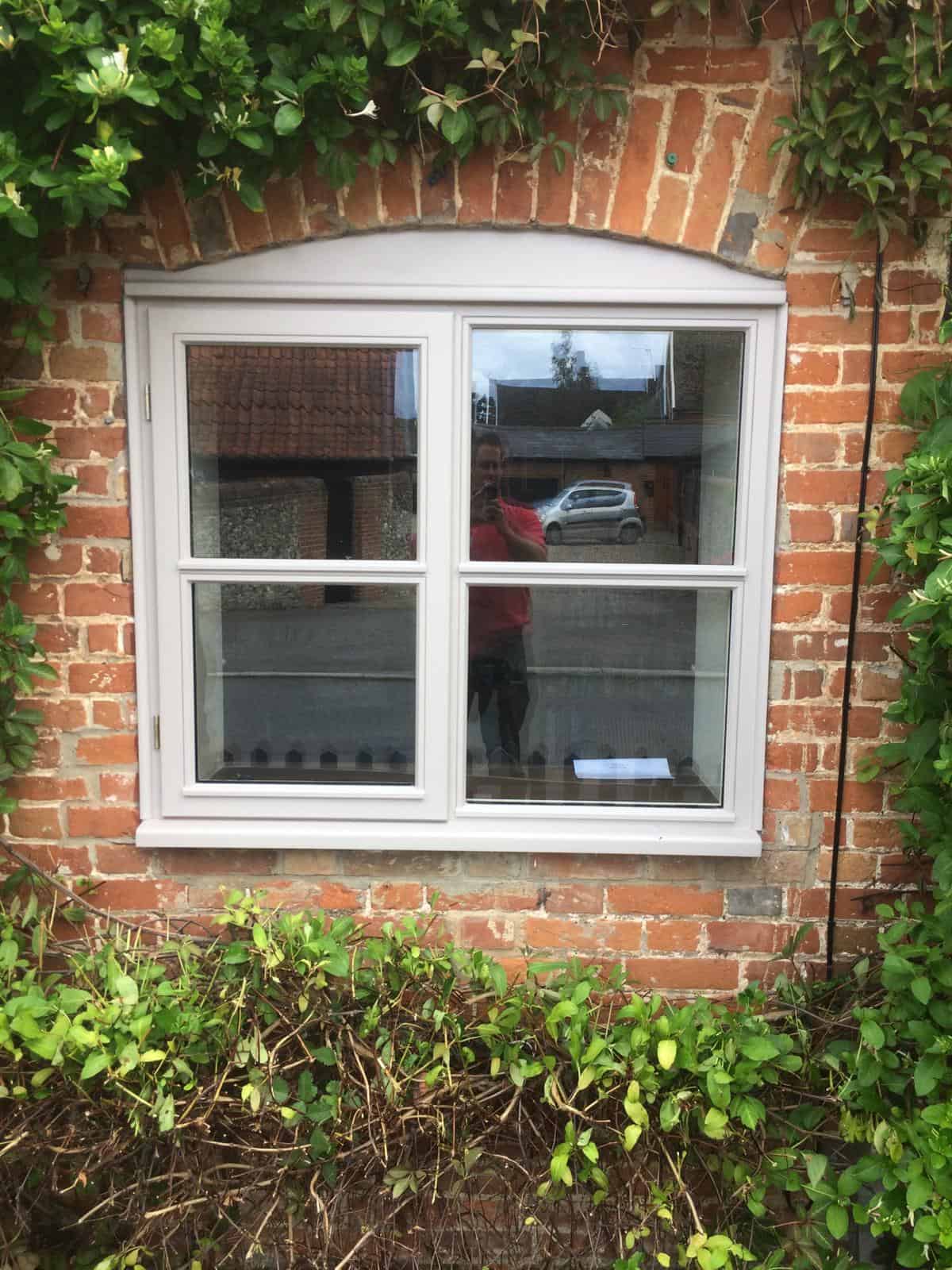 Double glazing installer installing cream windows