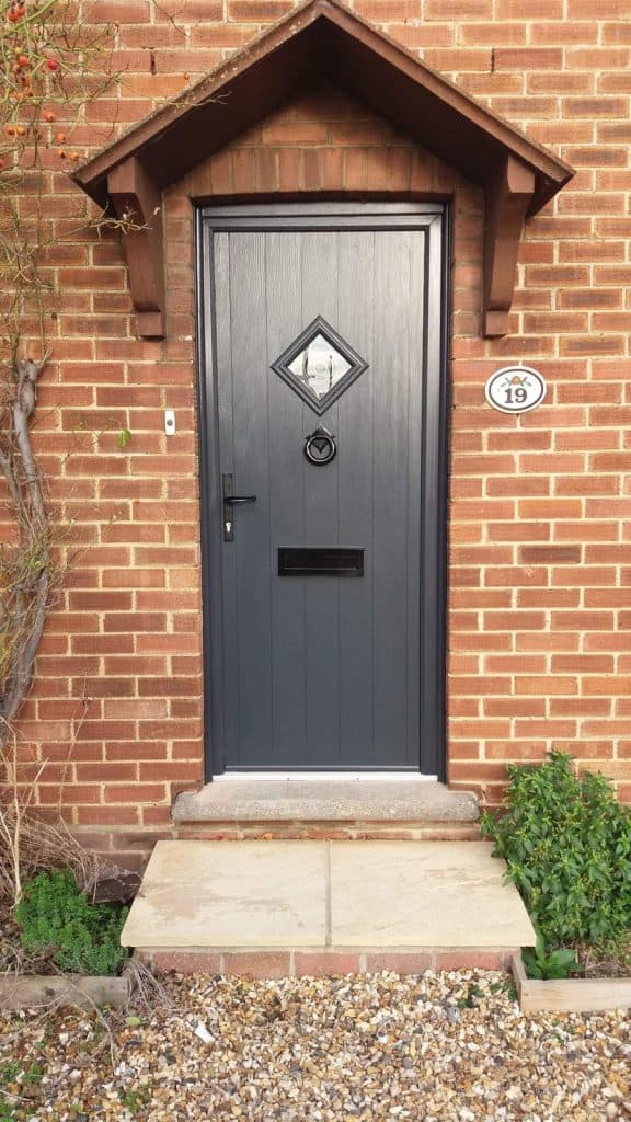 Black composite front door with wooden small porch